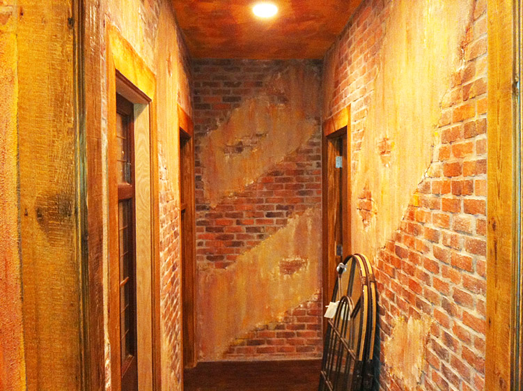 Completed distressed faux brick walls and wood framing at Patron Tacos & Cantina by Paramount Projects General Contractors